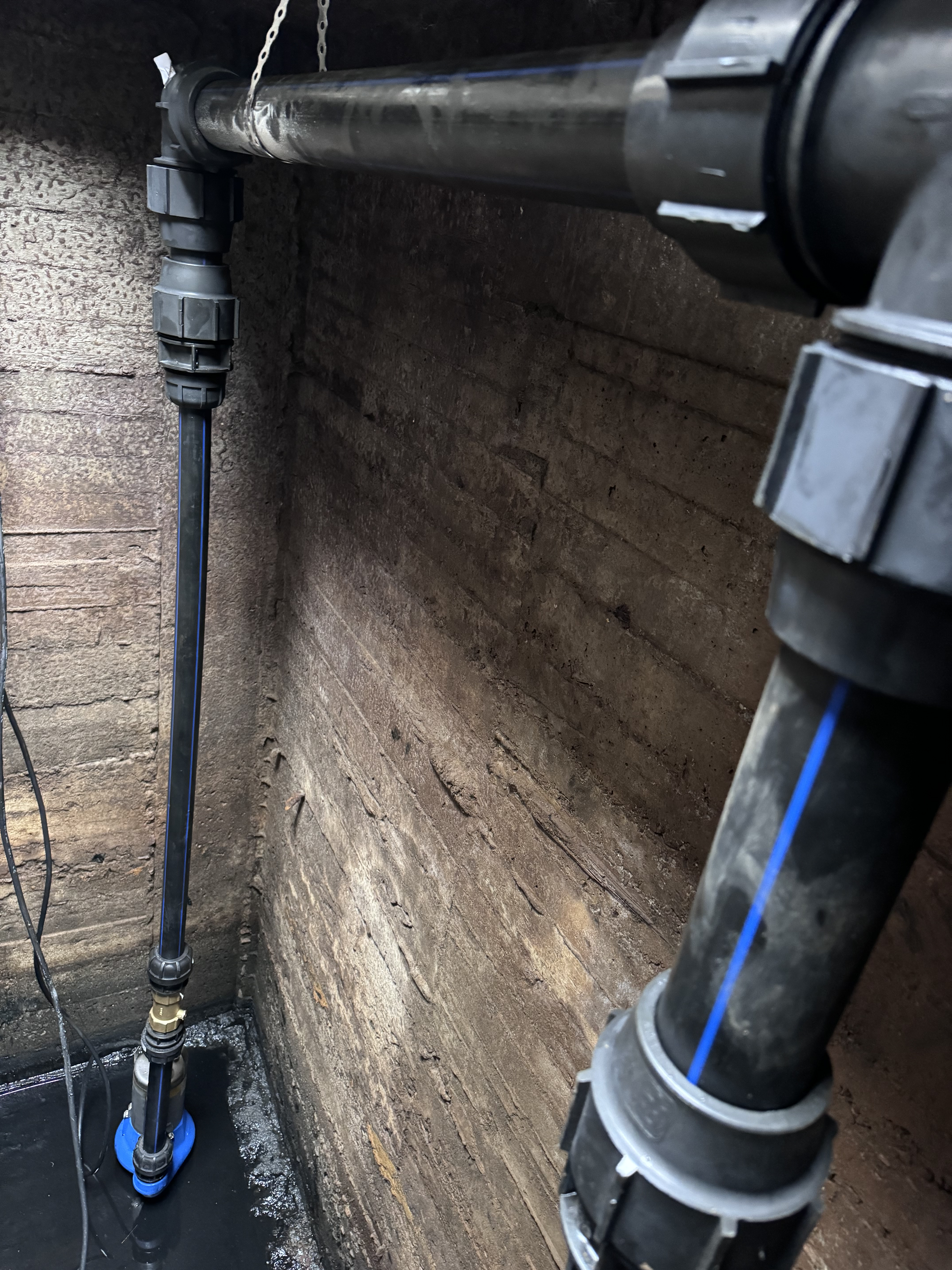 Brunnsinstallation med två nedsänkpumpar och avgänger i polyetenslang.